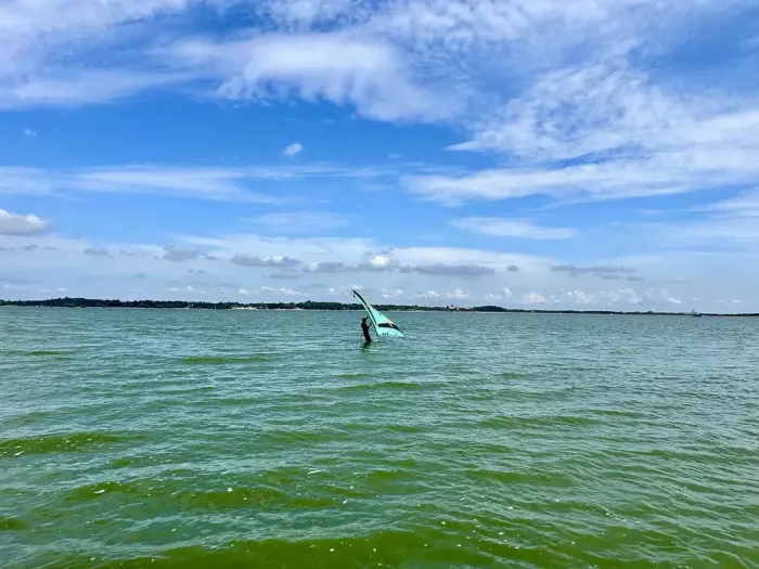 A rider on a hydrofoil board far out on the water