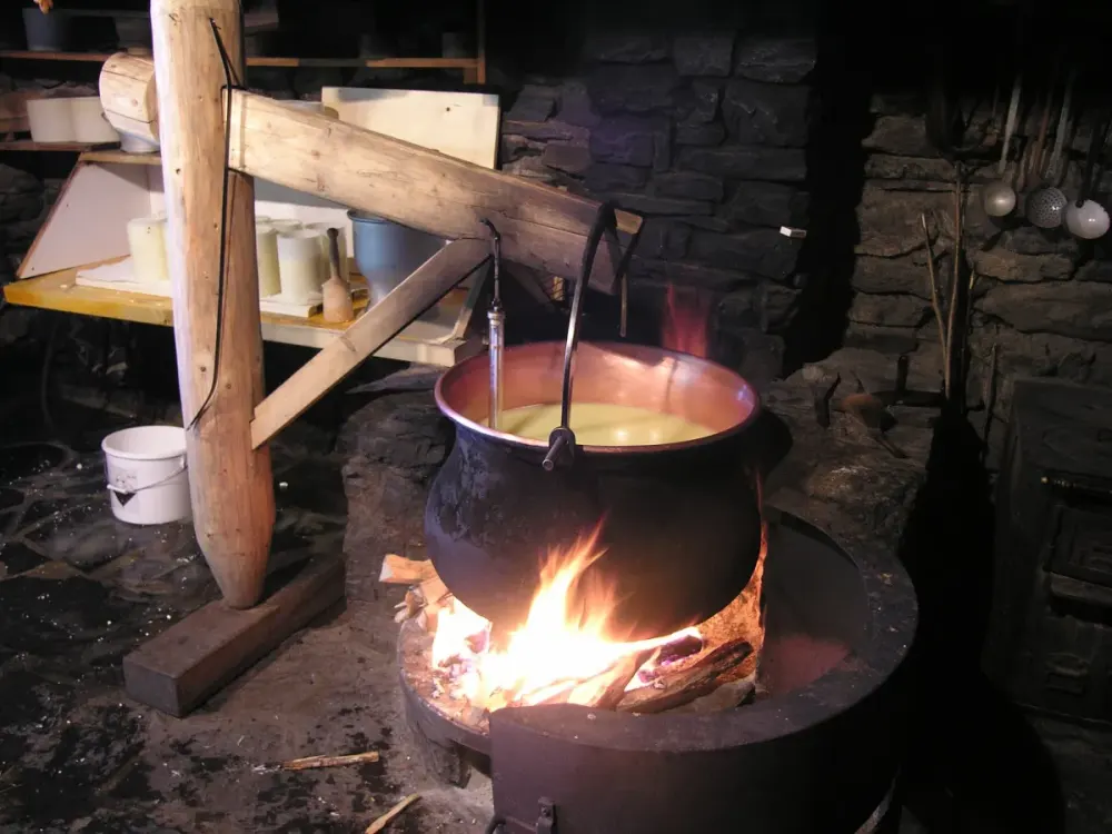 Milk heating in a copper cauldron over a wood fire