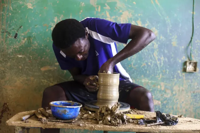 A potter shaping clay on a spinning wheel