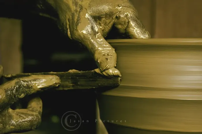 A potter shaping clay on a spinning wheel