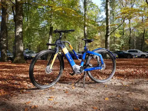 An electric bike on a gravel path with the motor and battery visible
