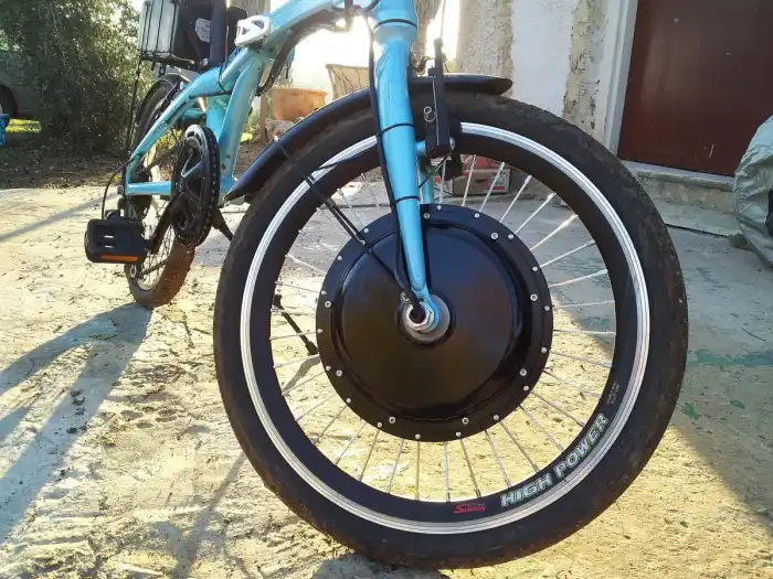 An electric bike on a gravel path with the motor and battery visible