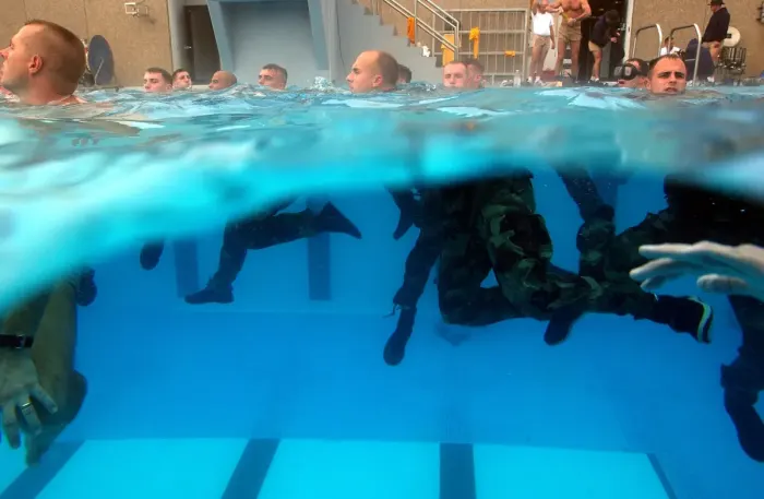 A scuba diver underwater in a wetsuit with tanks and mask