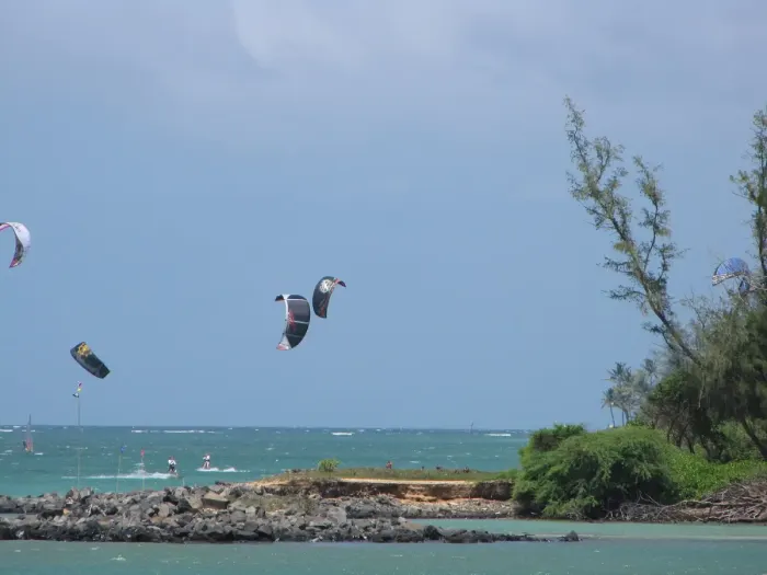 A kitesurfer riding across the water with a power kite overhead