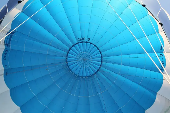 Looking up into the open envelope of a hot air balloon