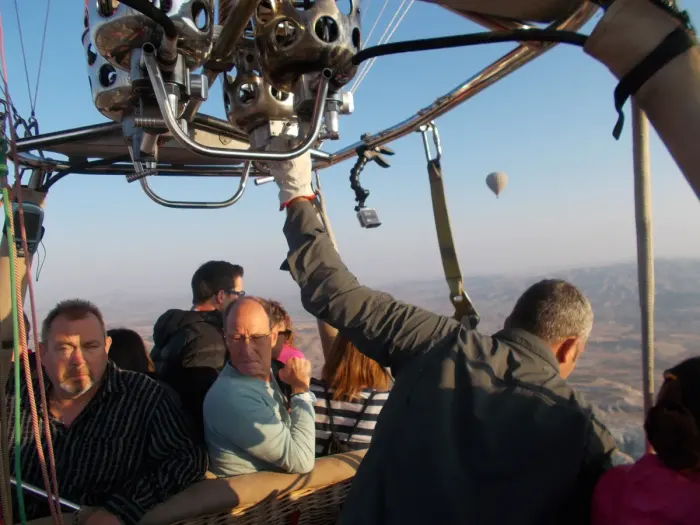 Passengers in a balloon basket in flight, another balloon beyond