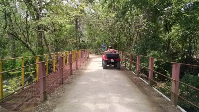 A quad bike on a dirt track, rider in helmet