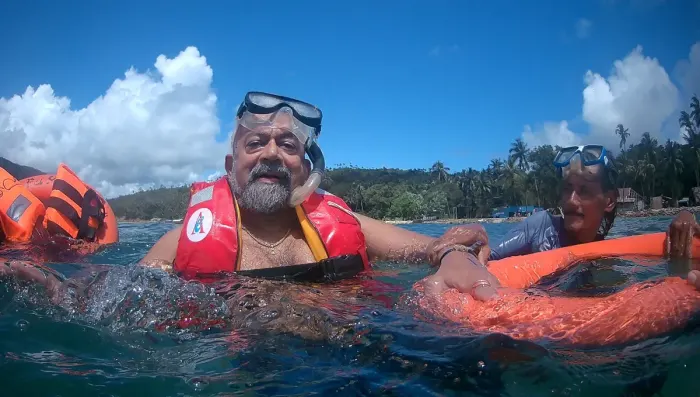 A snorkeler floating face down in clear shallow water