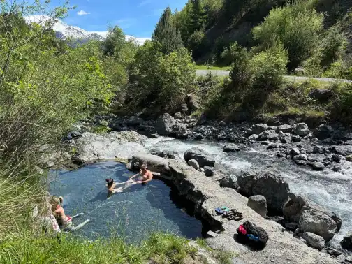 An outdoor thermal pool with steam rising off the water
