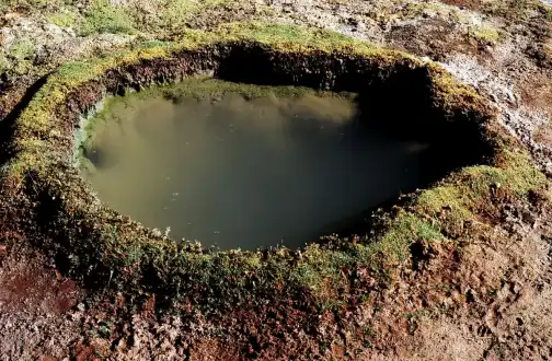 An outdoor thermal pool with steam rising off the water