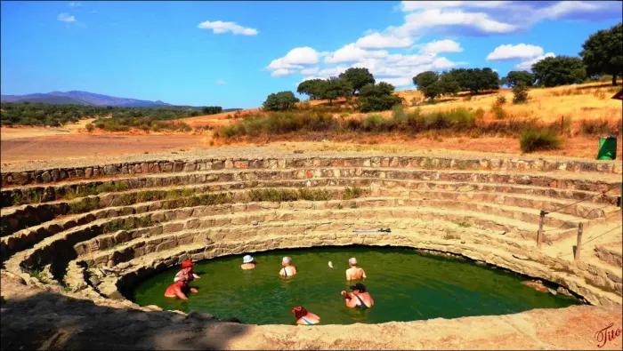 An outdoor thermal pool with steam rising off the water