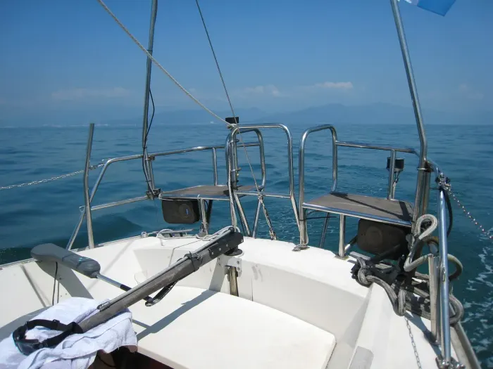 A sailing boat under white sails on open water