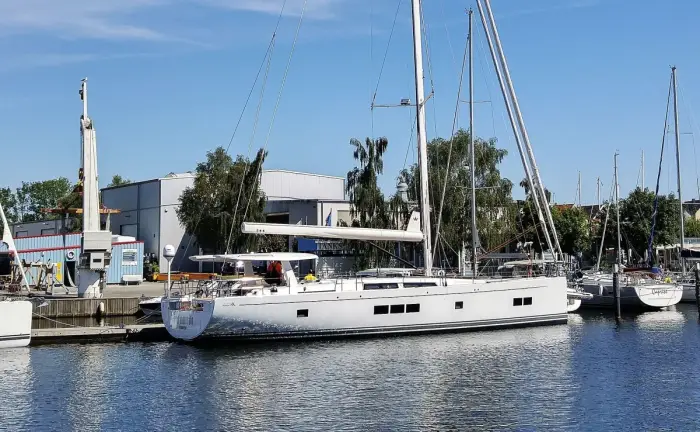 A sailing boat under white sails on open water