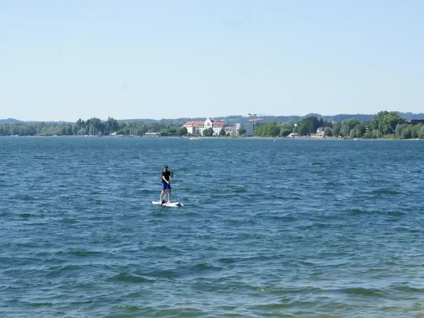 A paddleboarder on a wide calm lake