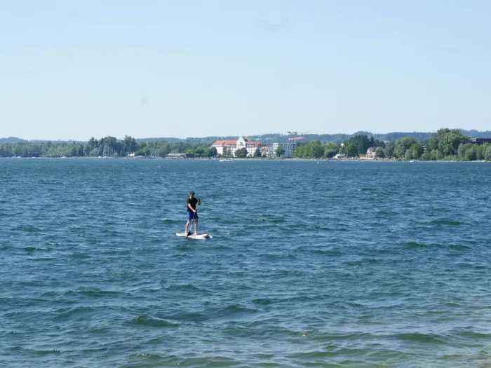 A paddleboarder on a wide calm lake